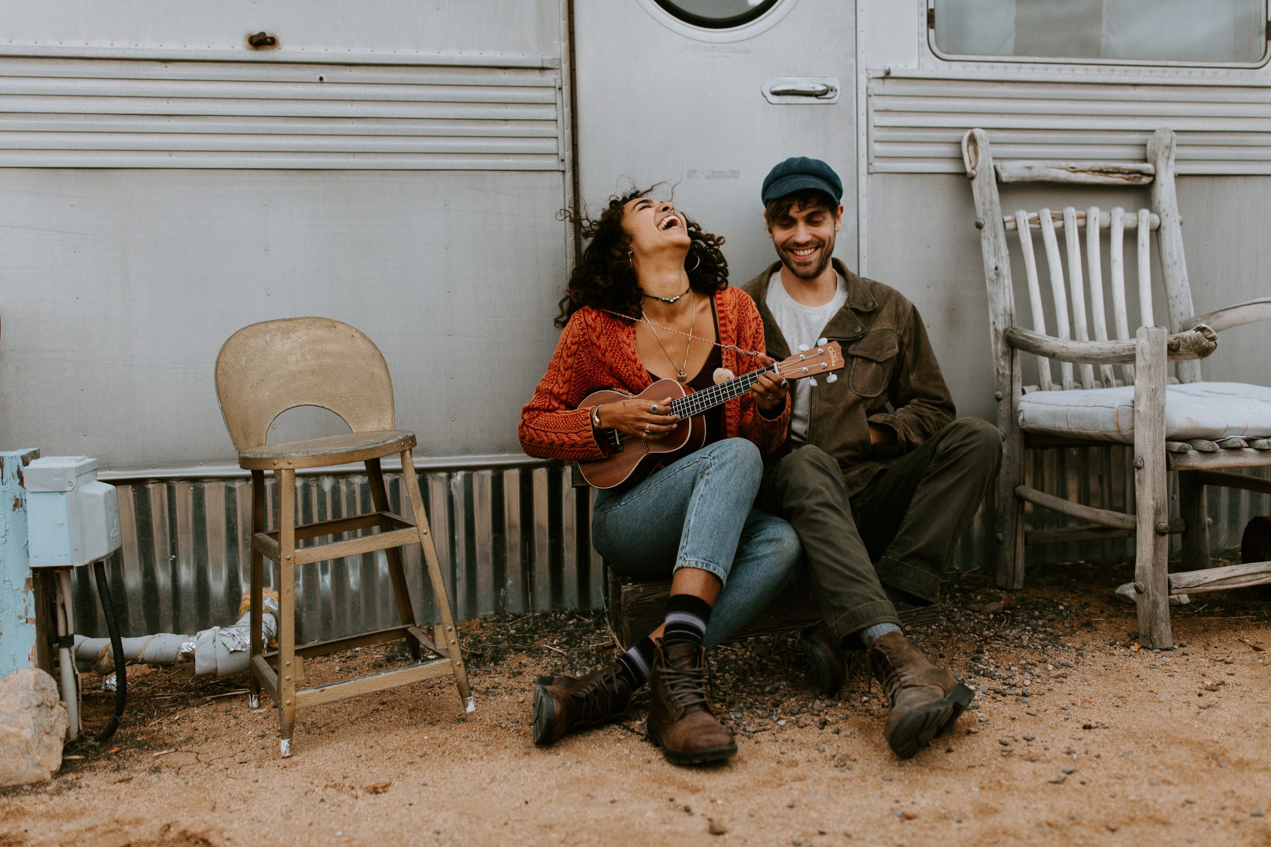 couple laughing and playing the okee by an airstream trailer