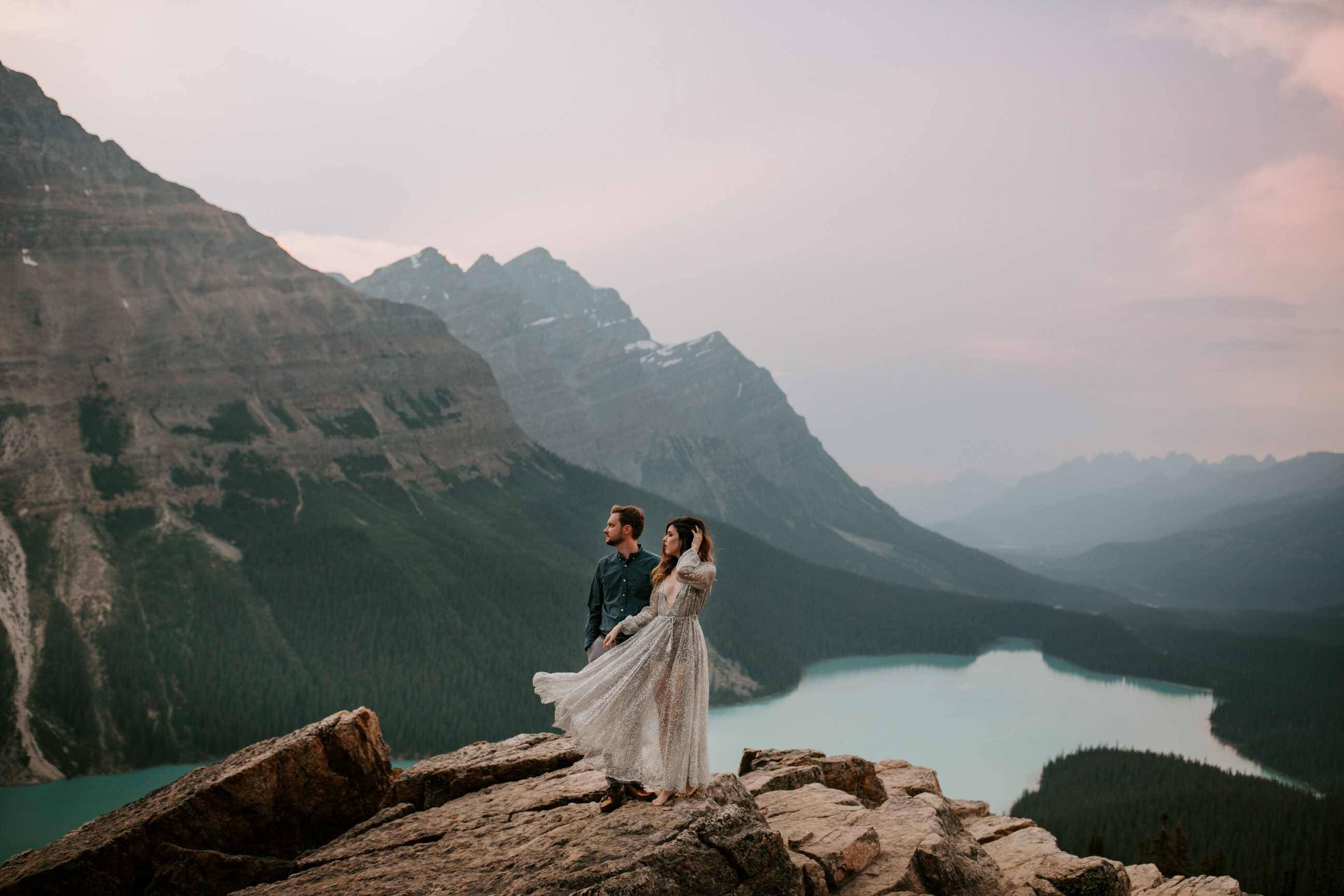 Adventurous couple standing on top of a mountain at Peyto Lake Alberta for an anniversary adventure session