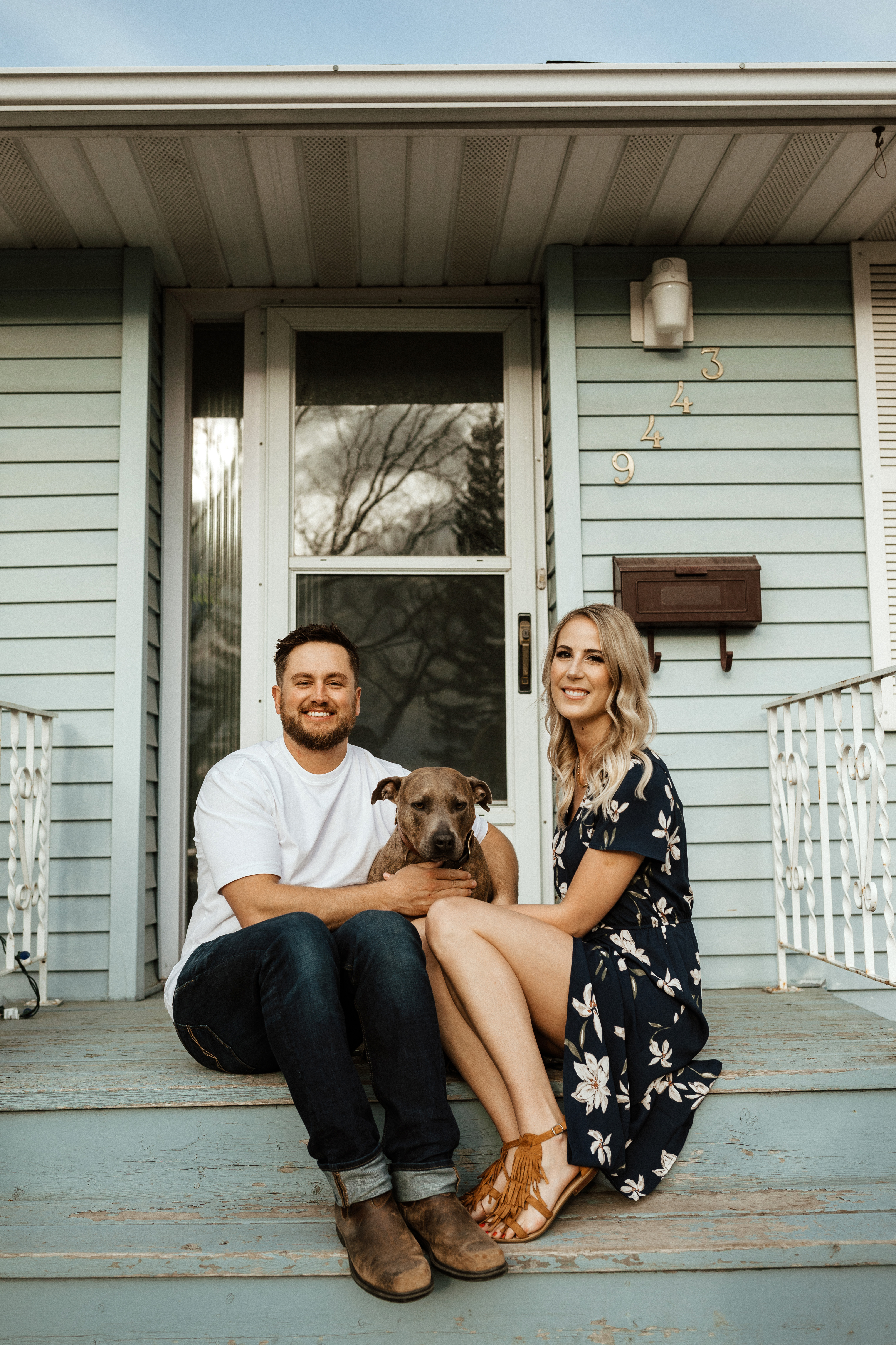 couple with their pitbull dog on their front porch