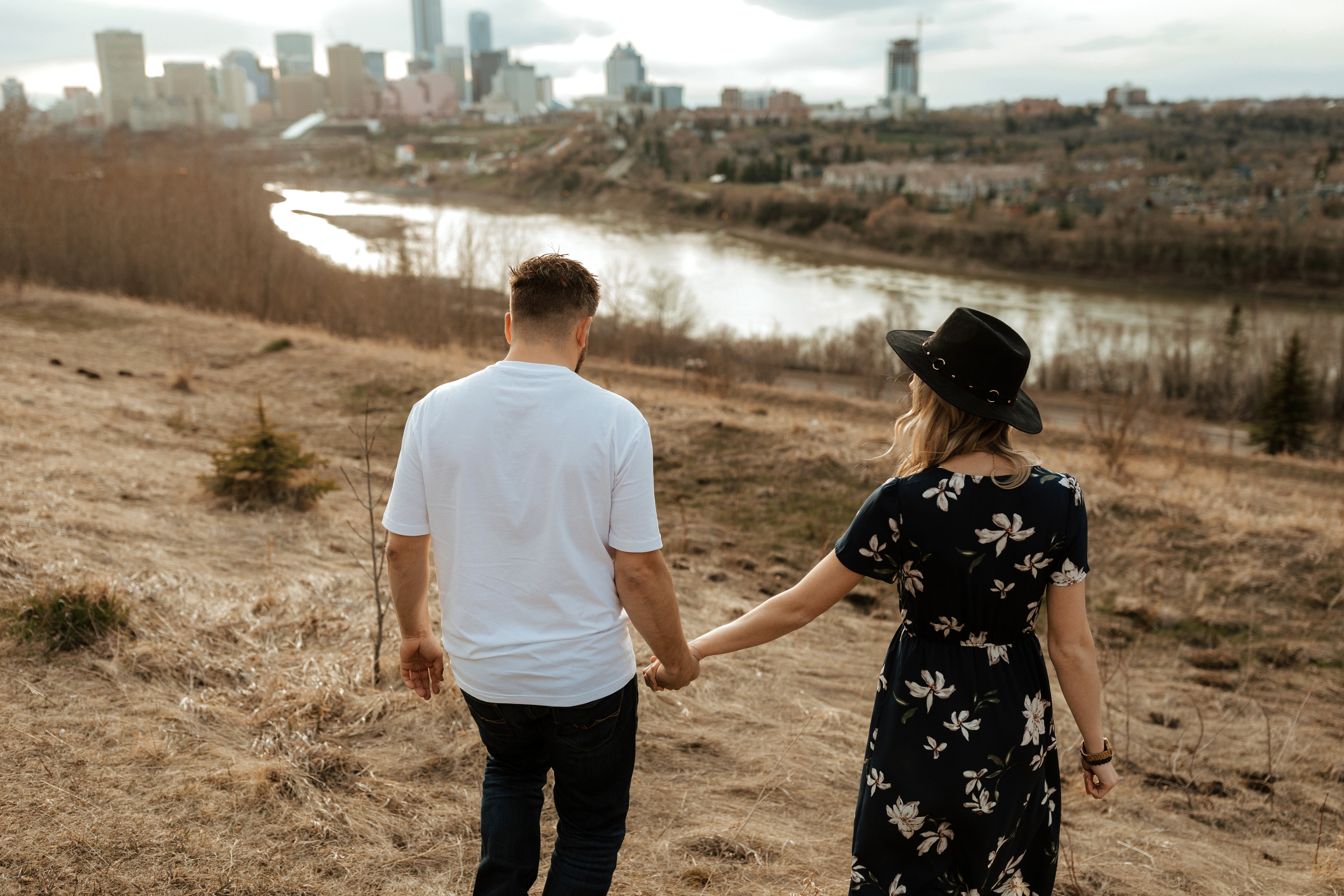 couple walking down to the river valley to do their engagement photos
