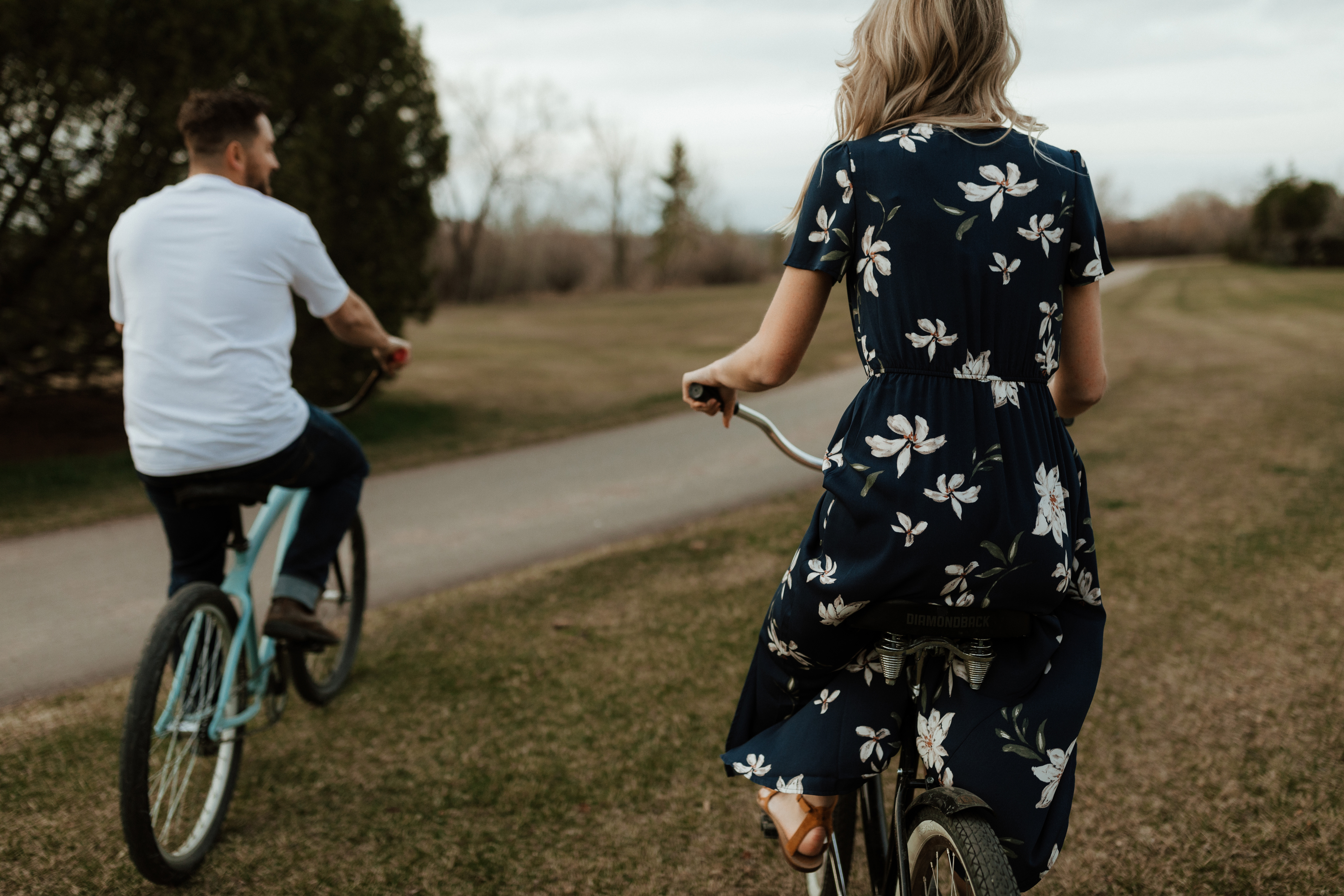 cute boho hipster couple go biking riding for their engagement photos