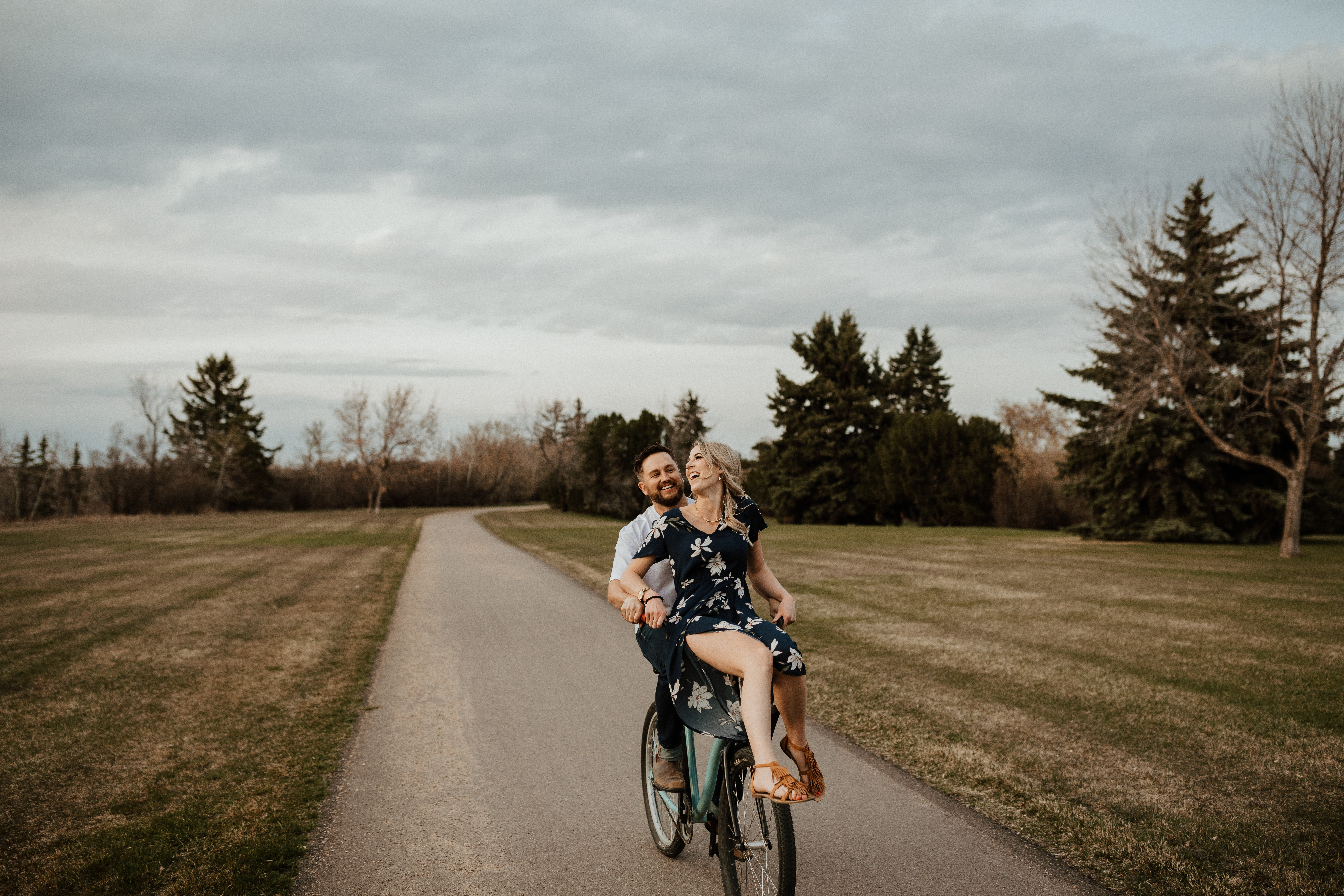 cute boho hipster couple go biking riding for their engagement photos