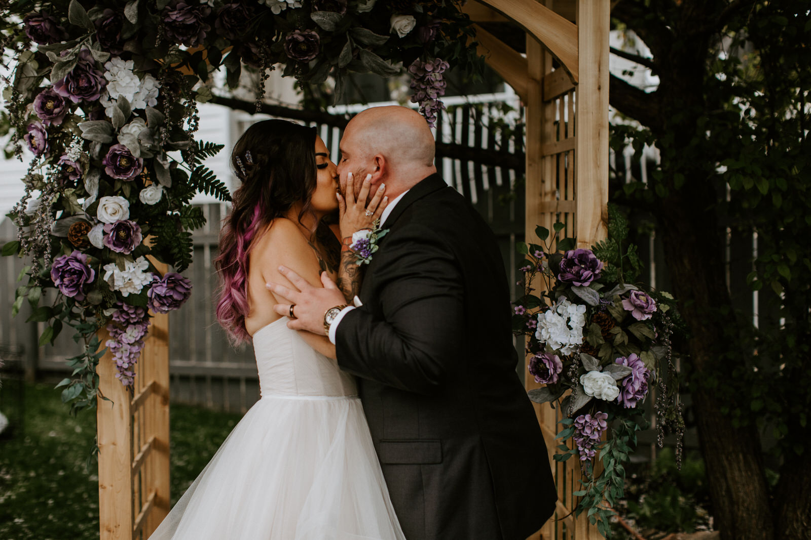 bride and groom first kiss intimate backyard wedding
